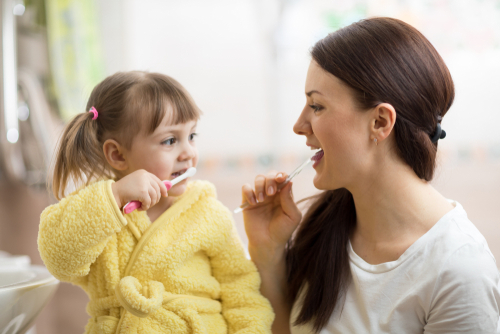 mother and daughter brushing their teeth