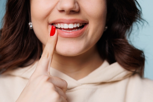 woman pointing to her smile