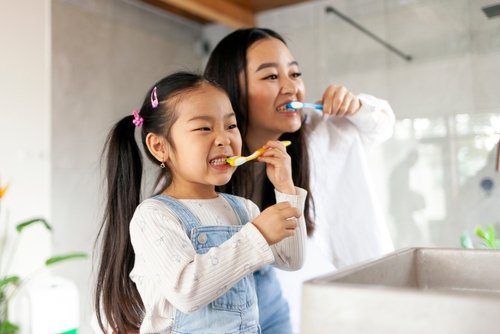 mother and daughter brushing their teeth